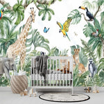 Papier Peint Jungle Bebe dans une chambre de bébé moderne et minimaliste avec des murs blancs et un sol foncé, un berceau blanc, une couverture grise à pompons, des peluches, des jouets en bois et un tapis à motif noir et blanc. Illustration aquarelle de jungle vivante avec un éléphant, une girafe, un zèbre, un lion avec son petit, un lémurien, un toucan, un perroquet, et des papillons entourés de feuillages tropicaux luxuriants