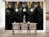 Papier Peint Tropical Fond Noir Exotique dans une salle à manger contemporaine avec table en bois naturel, chaises beiges et éclairage suspendu blanc. Motif d'illustration de feuilles tropicales dorées et noires superposées, sur un fond noir, dans un style moderne et élégant.