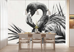 Tapisserie Oiseaux Noir Et Blanc dans une salle à manger contemporaine avec table en bois naturel, chaises beiges et éclairage suspendu blanc. Illustration en noir et blanc d'un flamant rose stylisé entouré de feuilles exotiques avec des détails minutieux des plumes et des feuilles de palmiers.