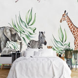 Tapisserie Panoramique Jungle Enfants Elephant Animal dans une chambre à coucher apaisante avec lit blanc, table de chevet moderne, et plantes vertes. Illustration de style aquarelle représentant une scène de savane africaine avec des éléphants, une girafe, un zèbre, des lions et des oiseaux en vol, entourés de luxuriants feuillages verts.