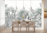 Papier Peint Panoramique Vegetal Noir Et Blanc dans une salle à manger contemporaine avec table en bois naturel, chaises beiges et éclairage suspendu blanc. Illustration d'une dense jungle tropicale avec des feuilles luxuriantes et exotiques, dessinée au trait, incluant des feuilles de bananier, des palmiers et d'autres végétations tropicales distinctives dans une palette de nuances de vert et gris-vert doux.