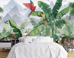 Papier Peint Foret Bebe dans une chambre à coucher apaisante avec lit blanc, table de chevet moderne, et plantes vertes. Illustration d'une scène de jungle tropicale vibrante avec des zèbres, des flamants roses, des perroquets, des toucans et des papillons parmi des plantes et des fleurs luxuriantes, avec des montagnes en arrière-plan.