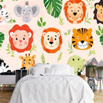 Papier Peint Jungle Enfant Panoramique dans une chambre à coucher apaisante avec lit blanc, table de chevet moderne, et plantes vertes. Illustration de visages d'animaux de la savane africaine, incluant des zèbres, éléphants, lions, tigres, girafes et léopards, entourés de feuilles tropicales.