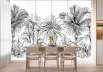 Papier Peint Jungle Tropical Noir Et Blanc Big Panoramique dans une salle à manger contemporaine avec table en bois naturel, chaises beiges et éclairage suspendu blanc. Illustration en gravure noir et blanc de palmiers et une végétation luxuriante tropicale.