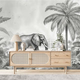 Papier Peint Chambre Enfant Jungle Noir Et Blanc dans un salon de style scandinave avec buffet en bois clair et décoration minimaliste. Illustration d'un éléphant marchant dans une jungle luxuriante avec des montagnes en arrière-plan, entouré de palmiers et de plantes tropicales en style gravure monochrome.