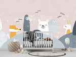 Papier Peint Animaux Foret Bebe Enfant dans une chambre de bébé moderne et minimaliste avec des murs blancs et un sol foncé, un berceau blanc, une couverture grise à pompons, des peluches, des jouets en bois et un tapis à motif noir et blanc. Illustration d'un paysage hivernal avec des collines enneigées, des arbres stylisés, et des animaux anthropomorphes incluant un renard, un ours polaire et un lapin, sous un ciel rose pâle avec des oiseaux noirs volant.