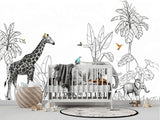 Papier Peint Jungle Bébé Tout Petit dans une chambre de bébé moderne et minimaliste avec des murs blancs et un sol foncé, un berceau blanc, une couverture grise à pompons, des peluches, des jouets en bois et un tapis à motif noir et blanc. Illustration en noir et blanc d'une scène de savane tropicale avec une girafe et trois éléphants marchant parmi des plantes exotiques, des lianes suspendues et des oiseaux colorés perchés sur les animaux et volant autour, dans un style de livre pour enfants.