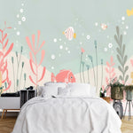 Papier Peint Chambre Bébé Poisson dans une chambre à coucher apaisante avec lit blanc, table de chevet moderne, et plantes vertes. Illustration sous-marine lumineuse et colorée avec des poissons tropicaux multicolores nageant parmi des plantes marines pastel et des bulles flottant dans l'eau, en style de livre pour enfants.