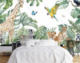 Papier Peint Jungle Bebe dans une chambre à coucher apaisante avec lit blanc, table de chevet moderne, et plantes vertes. Illustration aquarelle de jungle vivante avec un éléphant, une girafe, un zèbre, un lion avec son petit, un lémurien, un toucan, un perroquet, et des papillons entourés de feuillages tropicaux luxuriants