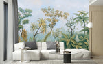 Tapisserie Panoramique Paysage Jungle dans un intérieur moderne et luxueux avec un grand canapé sectionnel blanc, une table basse en verre, et des touches dorées. Illustration d'une scène tropicale avec divers arbres et plantes exotiques sous un ciel légèrement nuageux, réalisée dans un style de peinture botanique classique.