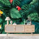 Tapisserie Jungle Oiseau dans un salon de style scandinave avec buffet en bois clair et décoration minimaliste. Illustration d'une jungle tropicale dense avec des feuilles vertes luxuriantes, des perroquets colorés, un cacatoès blanc, des toucans, et des fleurs tropicales vives comme des hibiscus rouge et jaune.