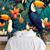 Papier Peint Forêt Animaux Exotique dans une chambre à coucher apaisante avec lit blanc, table de chevet moderne, et plantes vertes. Illustration de toucans perchés sur des branches entourées de végétation luxuriante avec des feuilles de monstera et des fleurs exotiques variées dans un style de livre pour enfants