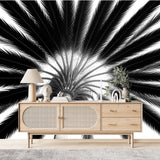 Papier Peint Panoramique Jungle Tropical dans un salon de style scandinave avec buffet en bois clair et décoration minimaliste. Illustration en contre-plongée d'un palmier avec des feuilles rayonnantes vers le ciel, réalisée en noir et blanc.