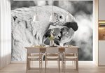 Papier Peint Tropical Noir Et Blanc Perroquet dans une salle à manger contemporaine avec table en bois naturel, chaises beiges et éclairage suspendu blanc. Illustration numérique d'un perroquet en gros plan, capturé en noir et blanc, avec des détails fins de ses plumes et de son bec, sur un arrière-plan flou.