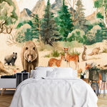 Papier Peint Panoramique Foret Enchantee Magique dans une chambre à coucher apaisante avec lit blanc, table de chevet moderne, et plantes vertes. Illustration d'une scène forestière animée avec des animaux tels qu'un ours, un renard, des daims, des lapins et des écureuils parmi des arbres et des fleurs, avec des montagnes en arrière-plan, réalisée dans un style aquarelle.