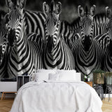 Tapisserie Noir Et Blanc Animaux dans une chambre à coucher apaisante avec lit blanc, table de chevet moderne, et plantes vertes. Illustration d'un groupe de zèbres serrés les uns contre les autres, avec leurs rayures distinctives en noir et blanc, dans un style photoréaliste.