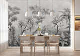 Papier Peint Jungle Tropical Noir Et Blanc Panoramique dans une salle à manger contemporaine avec table en bois naturel, chaises beiges et éclairage suspendu blanc. Illustration d'un paysage tropical dense avec une variété de plantes tropicales comme des palmiers, des fougères, et des plantes à larges feuilles.