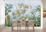 Tapisserie Panoramique Paysage Jungle dans une salle à manger contemporaine avec table en bois naturel, chaises beiges et éclairage suspendu blanc. Illustration d'une scène tropicale avec divers arbres et plantes exotiques sous un ciel légèrement nuageux, réalisée dans un style de peinture botanique classique.