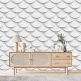 Papier Peint Blanc Ecaille De Poisson dans un salon de style scandinave avec buffet en bois clair et décoration minimaliste. Illustration d'un motif à écailles répétitives en blanc, représentant des demi-cercles alignés de manière ordonnée dans un style minimaliste. 